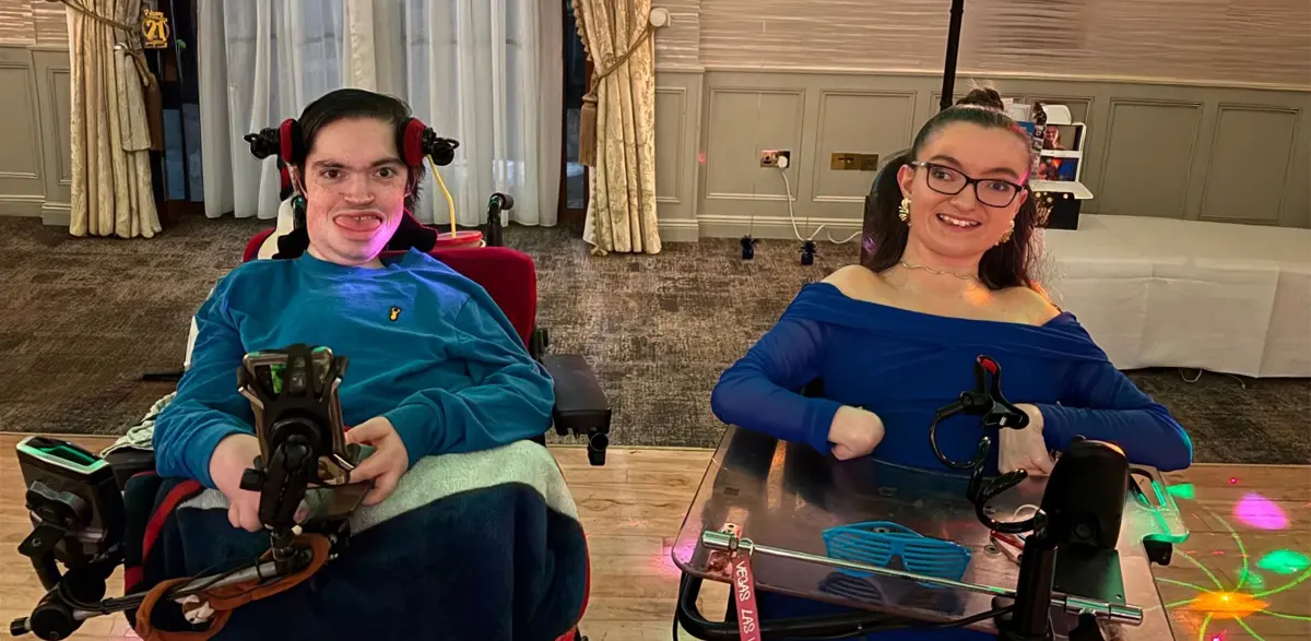 Two wheelchair users who are both smiling.